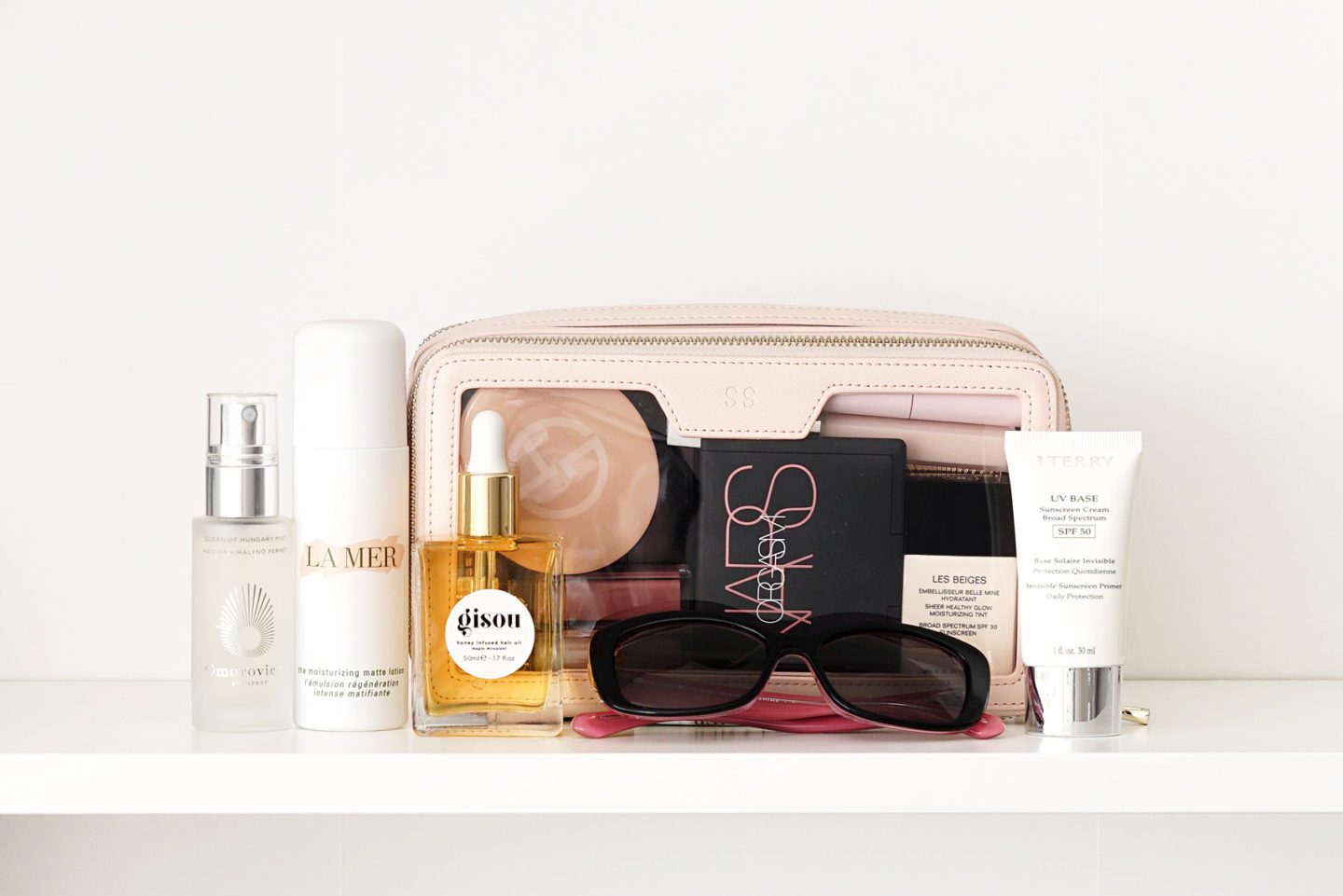 Best Clear Travel Makeup Bag from The Daily Edited, La Mer Moisturizing Matte Lotion, Gisou Hair Oil, By Terry Sunscreen